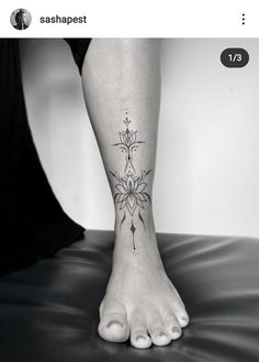 a woman's foot with a flower tattoo on the side of her leg and an arrow