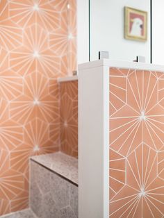 an orange and white bathroom with decorative wallpaper on the walls, along with a marble bench