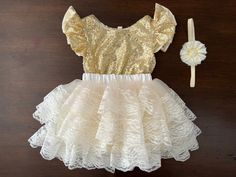 This baby girl vintage style, French Ivory and Gold Sequins party set is gorgeous. The French Ivory Fluffy Layered Skirt is super soft and fluffy. For your baby's comfort, it is made using soft fabric and lace in a beautiful French Ivory color that is perfect for the summer. The elastic waistband allows for full comfort. The chic baby gold sequins romper completes the style. It is made with shiny gold sequins and fully lined with a soft cotton fabric. The flutter sleeves make it girly and sophis Party Skirt With Cream Ruffles, Fitted Cream Sets With Ruffles, Cream Fitted Ruffle Sets, Cream Fitted Ruffled Sets, Cream Fitted Sets With Ruffles, Fitted Beige Sets With Ruffles, White Ruffled Sets For Dress-up Occasions, White Ruffled Sets For Dress-up, White Ruffled Dress-up Sets