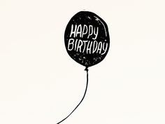 a black balloon with the words happy birthday written on it is floating in the air