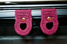 two pink crocheted baby booties with buttons