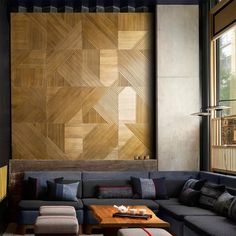 a living room filled with lots of furniture next to a large wooden paneled wall