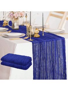 the table is set with blue linens and gold place settings