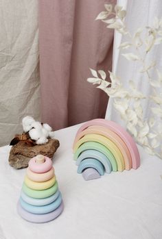 a stack of wooden toys sitting on top of a white table next to a cotton ball