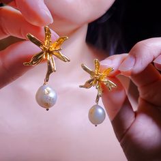 🌟 Dive into oceanic elegance with our 18k Gold Plated Pearl Earrings! 🌟  Are you ready to make a splash this summer? Our earrings aren't just any ordinary jewelry. These fab dangle earrings sport an enchanting starfish and flower design, giving you major tropical vibes. Handcrafted with love, these beauties flaunt lustrous pearls that shimmer like the sea. They are perfect for beachy outings, sun-kissed weddings, or just because you want to feel like a queen! 💖 Bonus: They make the ultimate " Elegant Flower Shaped Earrings For Beach, Elegant Starfish Charm Drop Earrings, Elegant Starfish Charm Earrings For Gift, Elegant Starfish Charm Earrings As Gift, Elegant Flower-shaped Earrings For Beach, Gold Elegant Earrings With Starfish Charm, Elegant Gold Earrings With Starfish Charm, Elegant Handmade Starfish Earrings, Yellow Gold Ocean-inspired Earrings For Gift