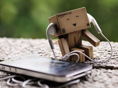 an image of a robot with headphones next to a cell phone on the ground