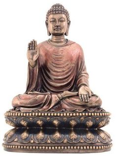 a buddha statue sitting in the middle of a bowl on top of a white surface