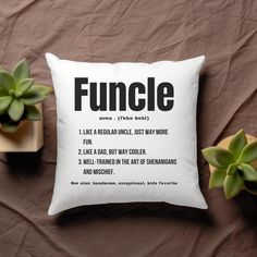 a pillow with the words funcle on it next to some succulents