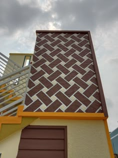 a brown and yellow building with a metal hand rail on top of it's side