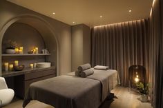 a spa room with two massage beds and candles