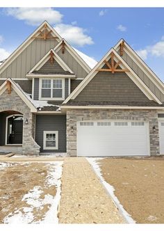 a large house with two garages and snow on the ground