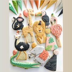 an assortment of decorated cookies in the shape of animals, birds and giraffes