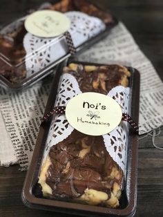 two trays filled with brownies and nuts on top of a wooden table next to each other