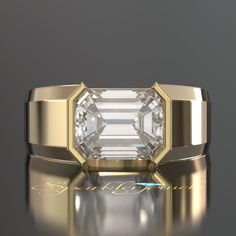 a ring with an emerald cut diamond in the center and gold lettering on the side