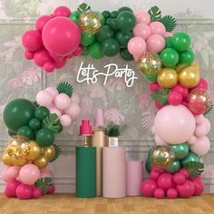 there are many balloons and confetti on this party arch that says let's party