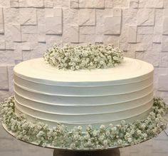 there is a white cake with flowers on the top and bottom layer, sitting on a pedestal