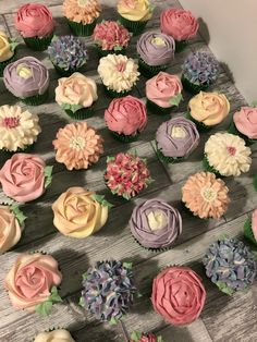 cupcakes decorated with flowers are arranged on a table