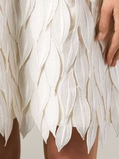 a close up of a woman's skirt with white leaves on it and the bottom part of her pants