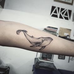 a small whale tattoo on the arm