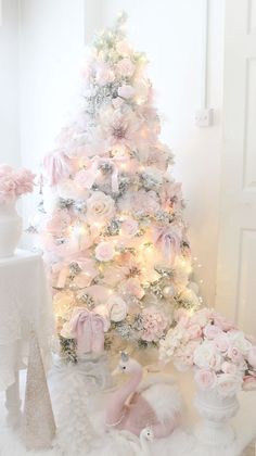 a white christmas tree decorated with pink flowers