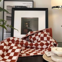 the table is covered with red and white checkered cloths, coffee cup and saucer