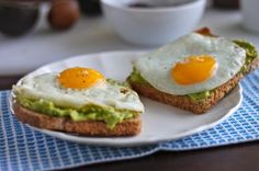 two eggs are on toast with avocado