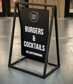 a sign for burgers and cocktails in a restaurant with no name on it