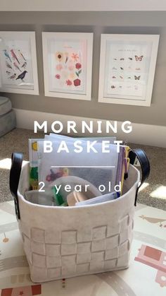 a white basket filled with lots of items on top of a table next to pictures