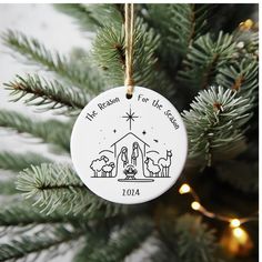 a ceramic ornament hanging from a christmas tree with the birth of jesus on it