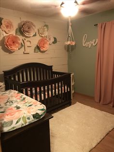 a baby's room with flowers on the wall and a crib in the corner