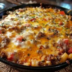 a casserole dish with meat, cheese and vegetables in it on a table