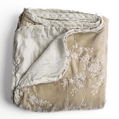 an old blanket with white flowers on it