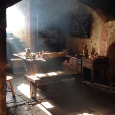 an old fashioned kitchen with sun shining through the window and cooking utensils on the table