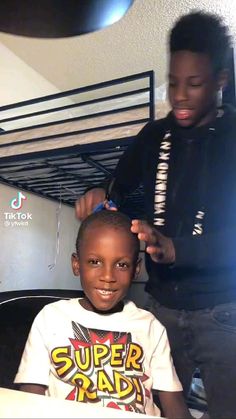 a young boy getting his hair cut by an adult