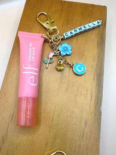 Hey, beauty lovers! Get ready to elevate your lip balm game with our Lip Balm Clip with Charms. This adorable accessory not only keeps your Elf lip balm handy but also adds a touch of personality with its cute charms. Clip it on for convenience and say goodbye to digging through your bag to find your lip balm! Perfect for on-the-go use, this charming clip ensures your lips stay moisturized wherever you are. Stay stylish and never lose your favorite lip balm again with our Lip Balm Clip with Charms! Simply select 3 charms from our options and give me the name you want on the clip! Elf Lip Gloss Keychain, Elf Lip Balm Keychain, Elf Lip Balm, Diy Crafts To Do At Home, Pink Lip Balm, Polaroid Picture Frame