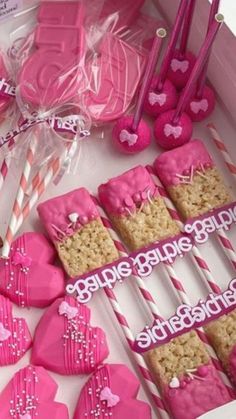 valentine's day cookies and candy sticks in a box with pink frosting on them