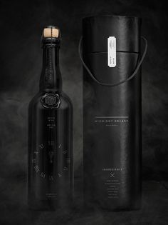 an empty black bottle next to a leather case