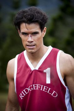 a young man wearing a red and white basketball uniform