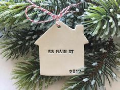 a house ornament hanging from a christmas tree