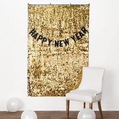 a white chair sitting in front of a golden new year banner