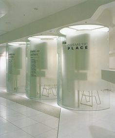 an empty room with white tile floors and round glass walls that have the words cosmetic place written on them