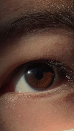 a close up of a person's eye with brown and white markings on it