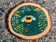 a painted wooden slice with a bee on it