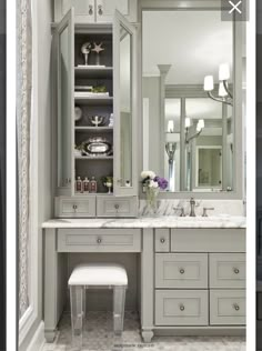 an image of a bathroom with gray cabinets and marble counter tops, along with a white stool