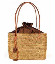 The Lisi Lerch Bali Bag collection is all handwoven by local artisans of the Tenganan region of Bali. Each weaver creates these works of art by using ata grass, a vine indigenous to the foothills of volcanoes on their beautiful Indonesian Island. The bags are then smoked in a coconut and honey fire to achieve their luscious golden hue. Our amazing team in Baltimore then adorns each bag so that they are as unique in character as the women who carry them. Whether you are strolling down the cobbled streets of Nantucket, sipping rosé in Charleston, or sunbathing poolside at your favorite resort, these one of a kind bags will surely turn heads! Size 7Wx5Hx4D 48 inch strap Materials Hand Woven Ata Grass Genuine Leather Strap Lining: Hand Loomed Cinnamon Cotton Features Drawstring Closure Crossbo Handwoven Palm Leaf Beach Bag For Travel, Brown Woven Rattan Bucket Bag, Eco-friendly Brown Bag With Open Weave, Brown Handwoven Jute Bucket Bag, Brown Rattan Travel Bucket Bag, Eco-friendly Woven Brown Bucket Bag, Brown Basket Bag With Open Weave, Eco-friendly Brown Woven Bucket Bag, Everyday Handwoven Rattan Shoulder Bag