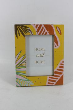 a yellow and pink frame with the words home is not home in gold lettering on it