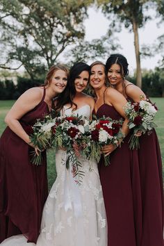 a group of women standing next to each other in front of some trees and grass