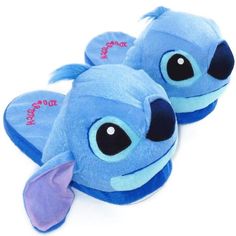 a pair of blue slippers with an elephant on the front and bottom, sitting on a white surface