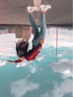 a woman is suspended upside down in the air over some snow and ice with her legs spread out