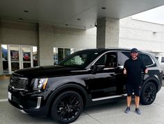 a man standing next to a black suv